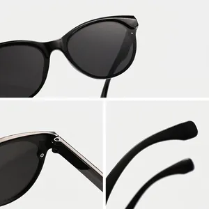 Eleganti occhiali da sole neri cat-eye con cerniera robusta e dettagli della montura fine