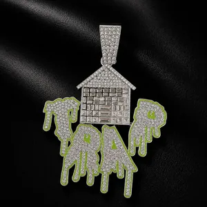 Detailed view of silver iced out TRAP house pendant featuring green drip enamel accents