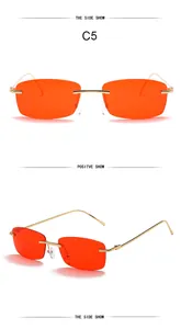 Detail view of vintage rimless square sunglasses with orange lenses and gold metal frames.