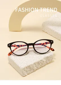Detalle de gafas retro de montura negra con patillas elegantes con estampado de leopardo
