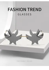 Detailansicht der grauen randlosen Sonnenbrille in Fledermausform mit Golddetails