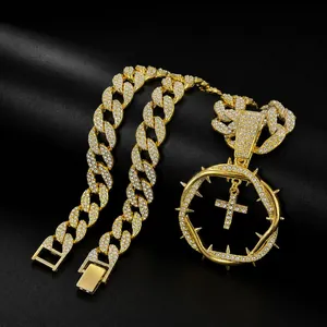 Close-up detail of gold plated iced out hip hop necklace with thorn cross pendant