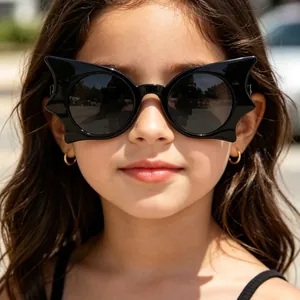 Süßes Kind trägt stilvolle schwarze Fledermaus-Sonnenbrille im Freien in der Sonne