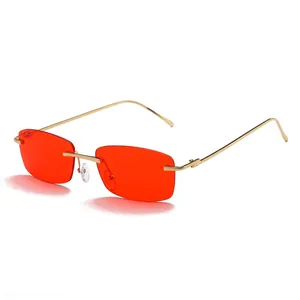 Vintage rimless rectangular sunglasses with red lenses and gold metal frames for women.