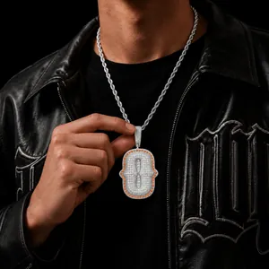 Detailed macro view of a silver hip hop pendant necklace with pavé zircons and orange accents