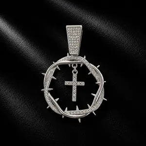 Detailed view of a silver-toned iced-out thorn crown pendant with a central cross