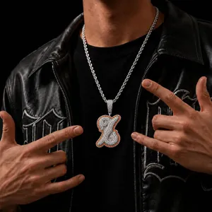 Detailed macro view of an iced out hip-hop letter pendant with orange border on rope chain