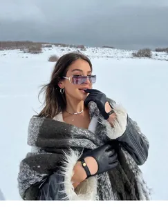 Futuristische Y2K zonnebril gedragen door een model in een besneeuwd winterlandschap.