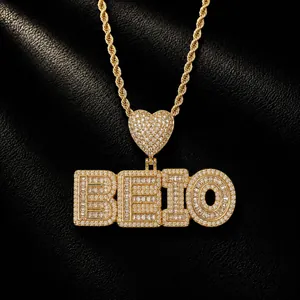 Macro view of iced-out custom letter pendant BEIO on gold rope chain