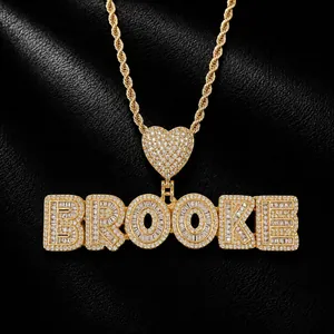Detailed view of personalized gold iced out BROOKE name necklace with heart bail