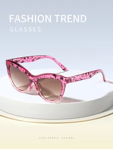 Lunettes de soleil vintage œil de chat roses avec motifs papillon sur un socle blanc