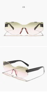 Close-up of rimless irregular sunglasses with yellow-pink gradient lenses and textured temples