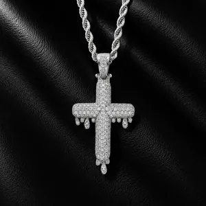 Macro detail of iced out silver dripping cross pendant encrusted with cubic zirconia