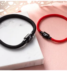 Macro-opname van zwart en rood gevlochten dierenriem armbanden met magnetische sluiting