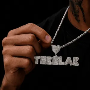 Close-up of custom iced-out letter pendant with heart link on hip-hop rope chain.