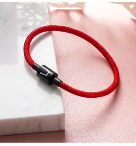 Gedetailleerde weergave van een rode gevlochten geluksarmband met magnetische sluiting