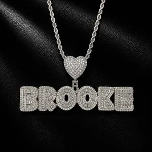 Close-up of silver-colored iced out zircon custom name pendant on a rope chain
