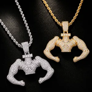 Dettaglio di pendenti hip-hop uomo muscoloso in oro e argento con zirconi incastonati