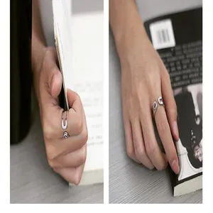 Detailansicht eines silbernen Sicherheitsnadel-Rings aus Titanstahl an einer Modellhand