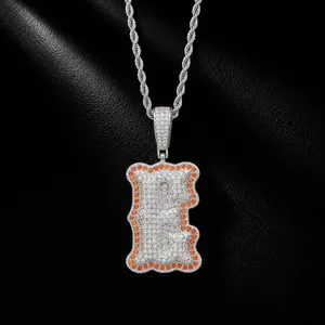 Detailed macro view of iced-out letter E pendant with orange stone border on rope chain