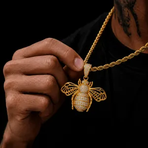 Close-up of a iced-out bee pendant necklace with a gold finish and hollow wings