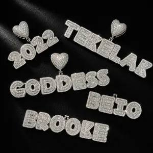 Close-up detail of personalized iced out cubic zirconia letter pendants in hip-hop style