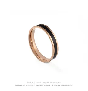 Detailaufnahme eines minimalistischen roségoldenen Titanrings mit schwarzem Emaille-Inlay