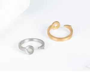 Dettaglio ravvicinato di anelli a amo vintage in acciaio al titanio color oro e argento