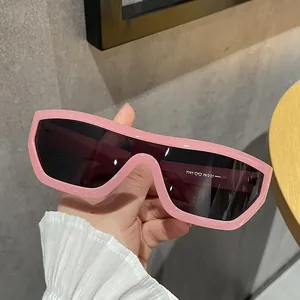 Dettaglio di occhiali da sole a maschera rosa oversize dallo stile punk e retrò.