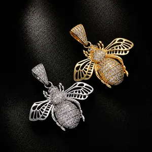 Macro shot of gold and silver hip hop bee pendants with sparkling zircons and hollow wings