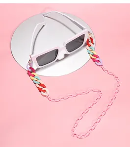 Detail view of colorful candy-colored acrylic glasses chain on pink background.