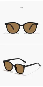 Close-up detail of classic black square frame sunglasses with protective brown lenses