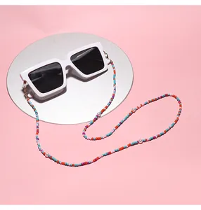 Close-up detail of a colorful beaded candy chain strap attached to white square sunglasses