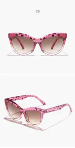 Vue détaillée de lunettes de soleil œil de chat roses rétro avec motifs papillon