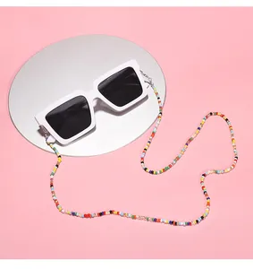 Detailed close-up view of a colorful beaded glasses chain attached to stylish white sunglasses