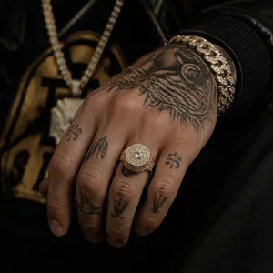 Gros plan d'une bague hip-hop dorée avec zircons cubiques sur une main tatouée
