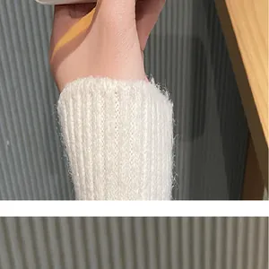 Detalle de calentadores de punto acanalado blanco esponjoso con textura suave