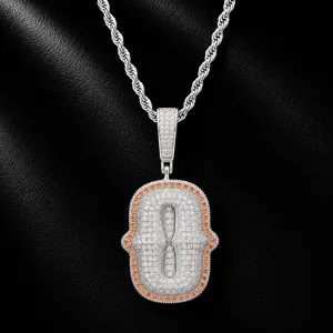 Macro view of iced out letter O pendant with orange zircon border on silver rope chain