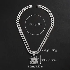 Detailed view of the iced out crown KING pendant with measurements on a black surface