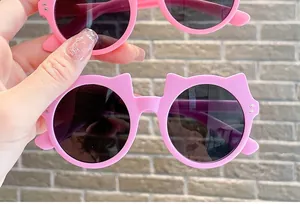 Close-up view of cute pink cat-ear children's sunglasses with stylish round dark lenses
