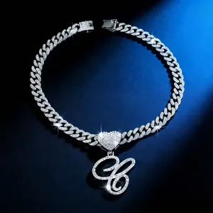 Close-up of iced out Cuban link necklace with heart connector and cursive B pendant