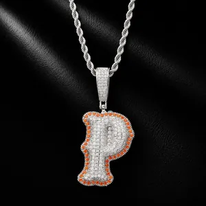 Close-up of iced out letter P pendant with orange and clear stones on black leather