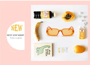 Lunettes de soleil rectangulaires orange rétro dans une mise à plat colorée avec des fruits