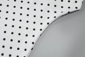 Detailaufnahme des schwarz-weißen Polka-Dot-Print-Stoffes für ein modisches Kleid