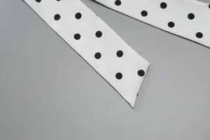 Detailansicht eines weißen Stoffbands mit klassischem schwarzem Polka-Dot-Print-Design