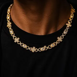 Close-up detail of luxury hip hop gold necklace with iced-out cross and evil eye patterns