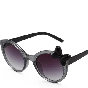 Cute children's round glitter sunglasses with stylish black bow accent on frame