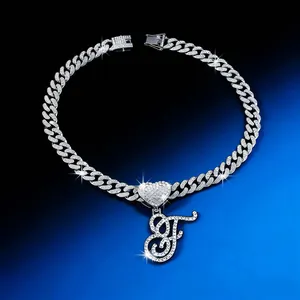 Detailed view of iced out Cuban chain with script letter F and heart pendant
