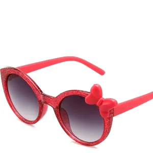 Kids red glitter round sunglasses featuring a 3D bow decoration and gradient lenses