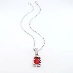 Macro view of a silver necklace featuring a sparkling rectangular red gemstone pendant